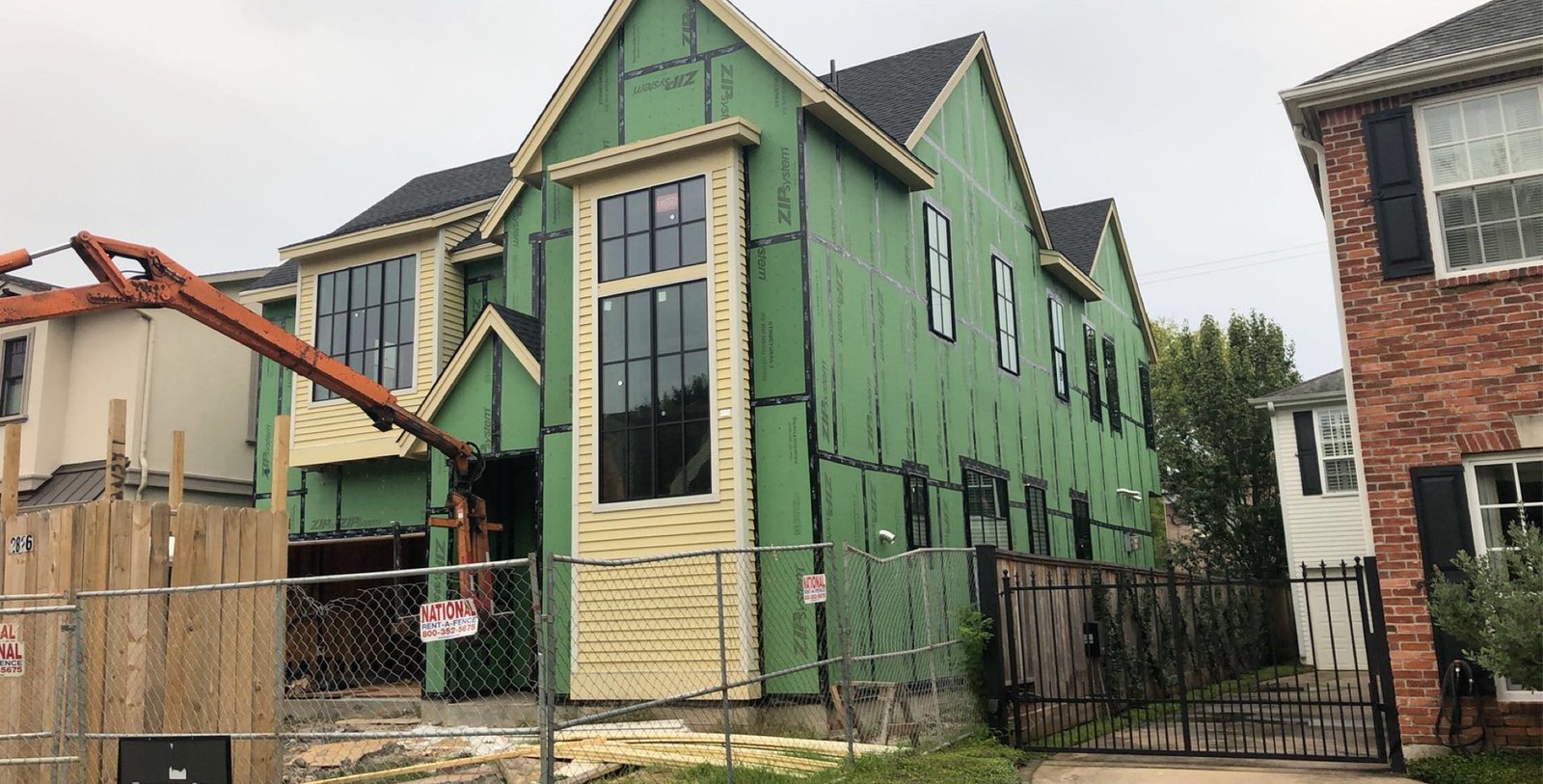 Exterior painting in Houston Heights, TX on a green home with cream trim